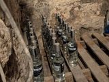 bottles of vodka are lined up on wooden pallets in a cave