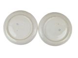 pair of white porcelain plates with blue and white designs on them