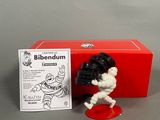 the figurine is in a red box with a black and white figure next to it