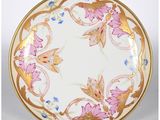 un gros plan d'une assiette décorée de fleurs, posée sur un support