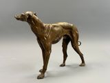 bronze statue of a dog standing on a white surface