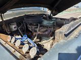 une vieille voiture avec le capot ouvert et le moteur à l'intérieur