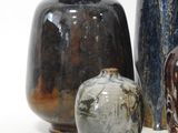 three vases sitting next to each other on a white surface