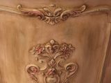 a wooden cabinet with ornate carvings on the top of it