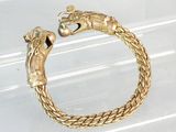 bracelet plaqué or orné d'une tête de dragon sur un fond transparent