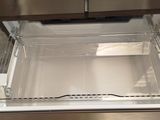 an open refrigerator with a door that has a drawer inside of it