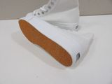 white sneakers with brown soles sitting on a white surface