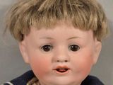 a doll of a boy with blonde hair and a sailor ' s outfit