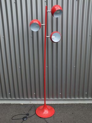 une photo d'un lampadaire rouge muni de trois lampes