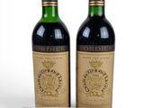 two bottles of wine sitting next to each other on top of a table