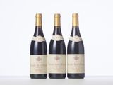 three bottles of wine are lined up on a table
