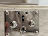 a close up of a metal switch on a white cabinet