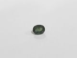 a green tourmaline stone on a white surface