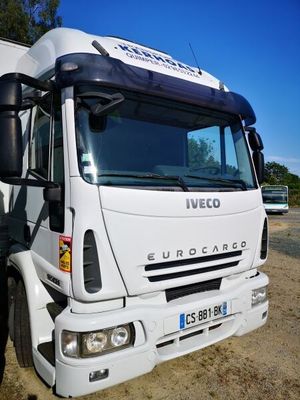 un homme debout à côté d'un camion garé sur le bord de la route