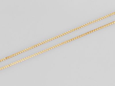 une paire de colliers en chaîne en or sur fond blanc
