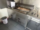 un grand évier en inox dans une cuisine où se trouve un grille-pain sur le plan de travail