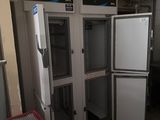 several refrigerators and freezers are lined up in a kitchen