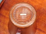 a close up of a wooden table with a cup on it