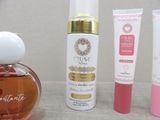 a bottle of perfume next to a tube of lotion and a tube of lotion