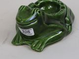a green frog that is sitting on a white table