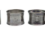 three silver metal cups are lined up next to each other