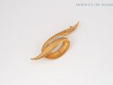 a gold leaf brooch with diamonds on it