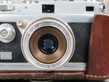 a close up of an old camera with a leather case