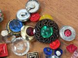 a lot of different colored buttons on a wooden table