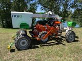 un tracteur avec une remorque attelée, dans l'herbe