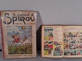 an old comic book sitting on top of a table next to a box of comics