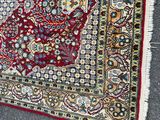 an image of a red and blue oriental rug laying on the ground