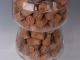 a glass jar filled with wine corks on a white surface