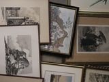 many framed pictures on the wall of a room