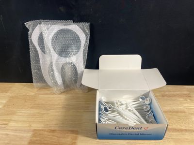 une boîte de brosses à dents posée sur une table à côté d'un tube de dentifrice