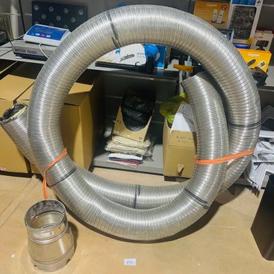 a large metal hose sitting on the floor next to a can of soda