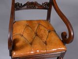 an old chair with a brown leather seat on a grey background
