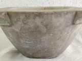 a large stone bowl sitting on a white surface