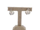 boucles d'oreilles en perles et diamants présentées sur un présentoir, sur fond blanc