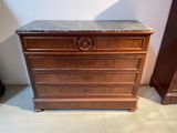 a wooden chest of drawers with a marble top