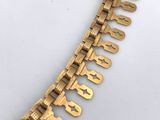 an image of a gold necklace with a chain that has a number of letters on it
