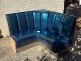 a blue bench that is outside on the sidewalk