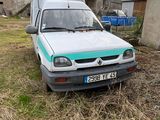 un camion garé dans l'herbe devant une grange