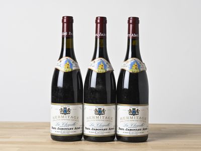 trois bouteilles de vin posées sur une table en bois