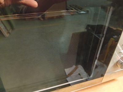 a person taking a picture of the inside of a microwave