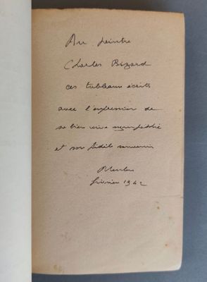 un livre ouvert avec une écriture manuscrite posé sur une table