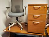 une image représentant un bureau avec une chaise et un classeur