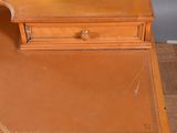 a small wooden desk with a mirror on top of it
