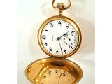une montre de poche en or posée sur une table