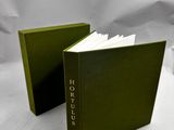 deux livres verts posés l'un à côté de l'autre sur une surface blanche