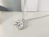 un gros plan sur un collier en diamants posé sur une table, à côté d'une tasse de café